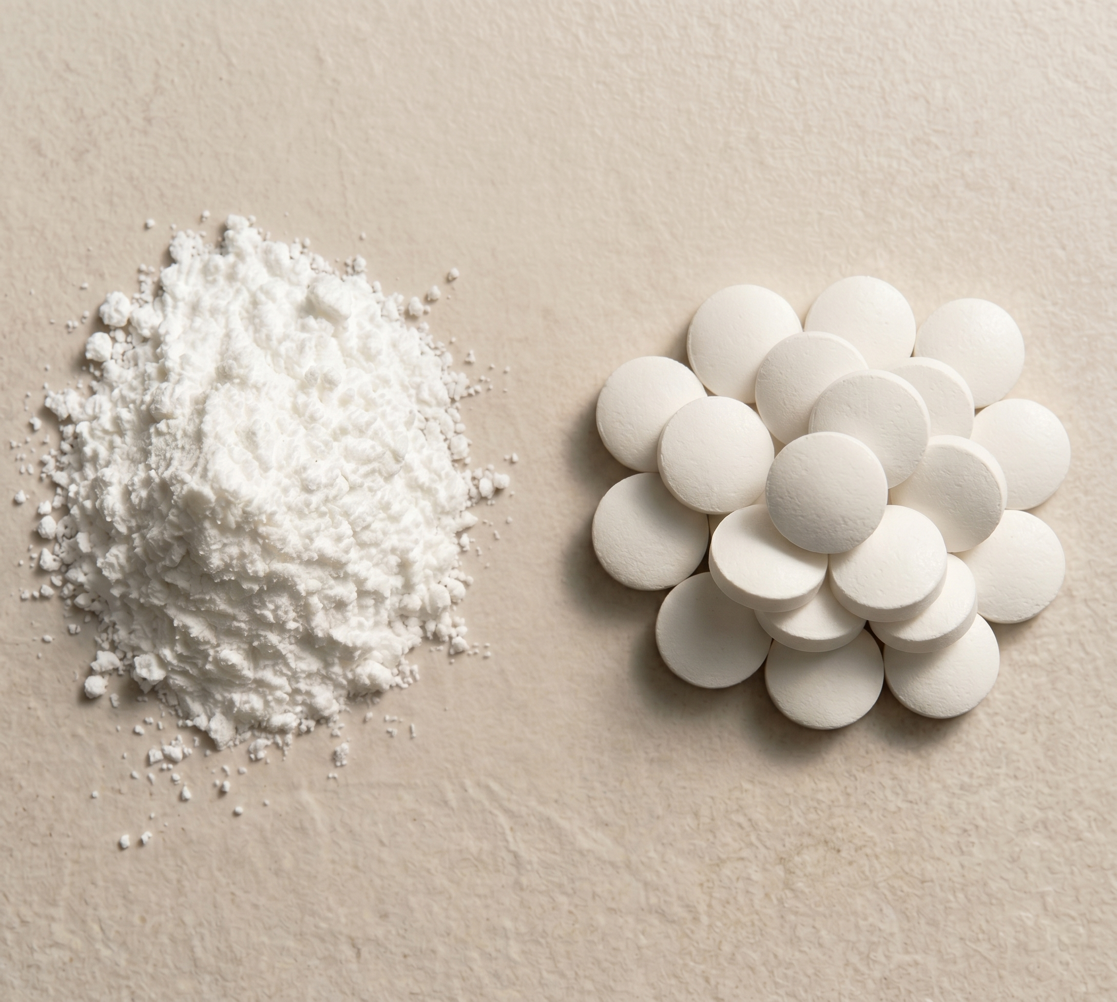 White powder and white tablets on a beige background